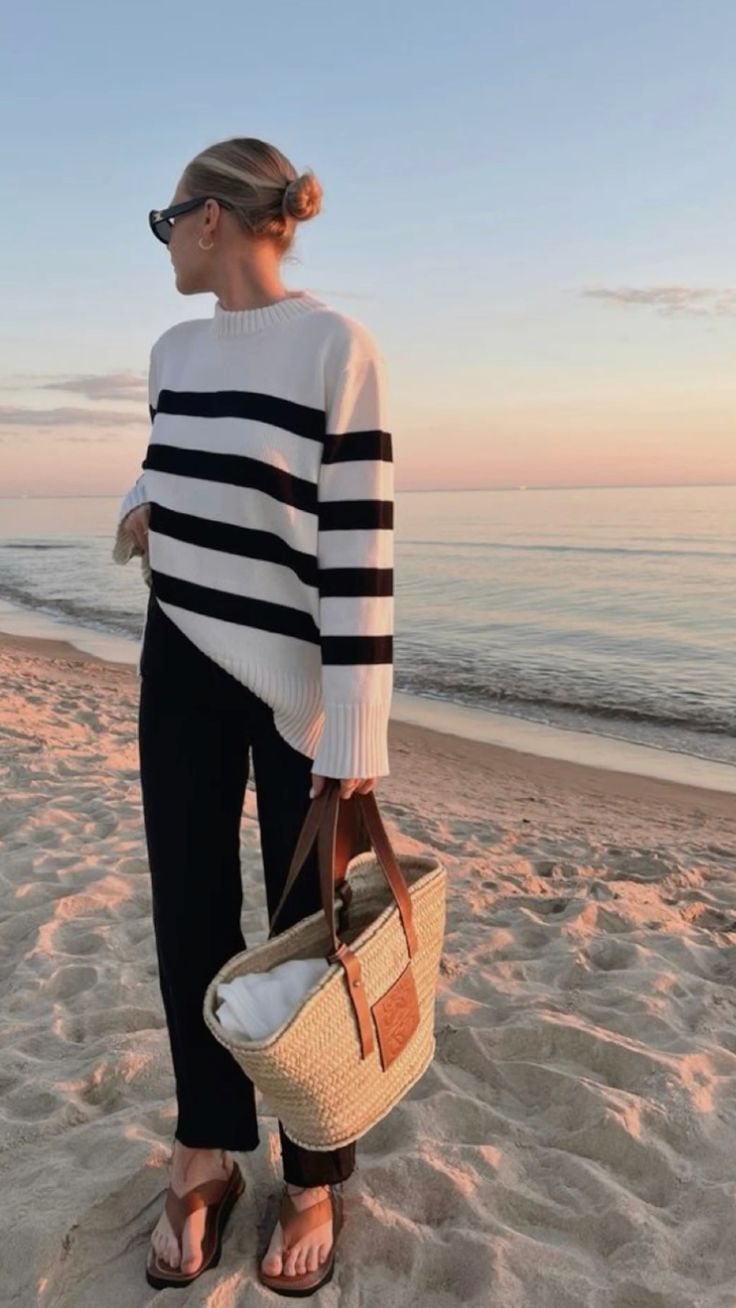 striped sweater and trousers paired with a LOEWE straw bag